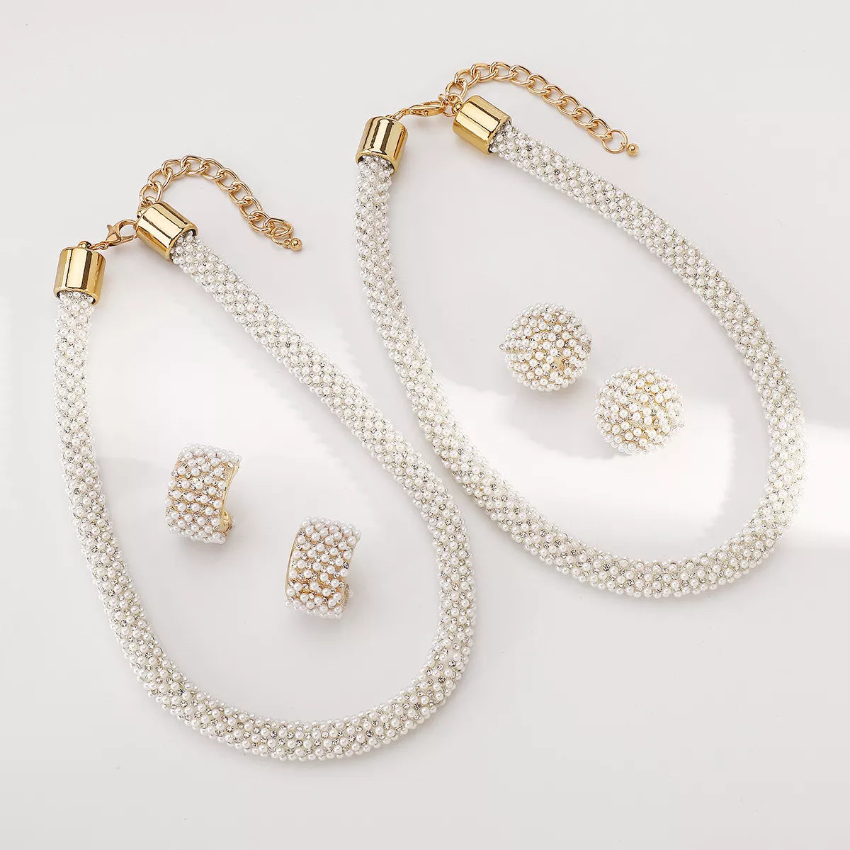 Pearl necklace and earring set with gold accents on white background