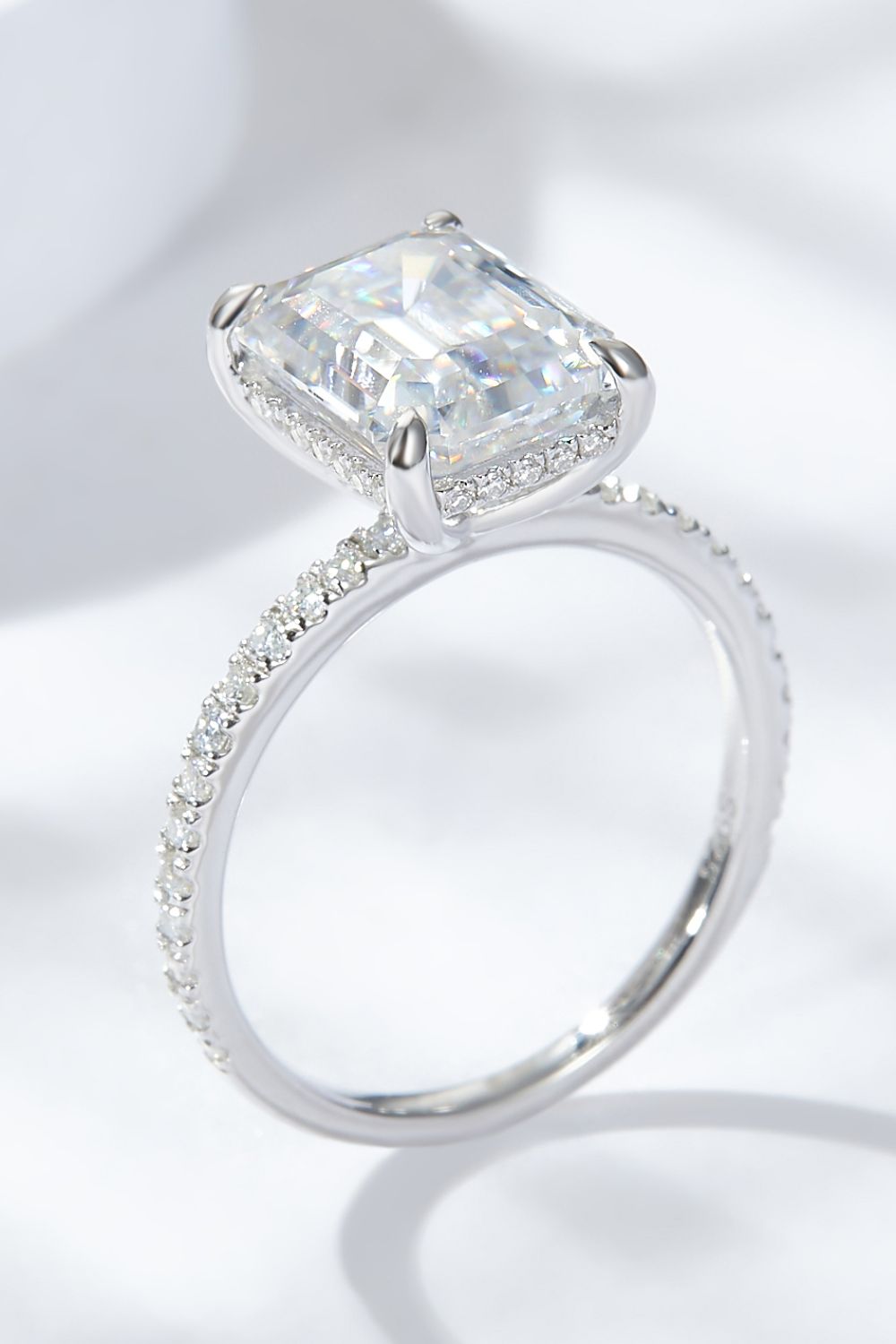 4 carat moissanite ring emerald cut featuring a sparkling center stone and a delicate band with smaller diamonds.