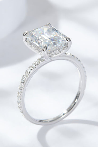 4 carat moissanite ring emerald cut featuring a sparkling center stone and a delicate band with smaller diamonds.