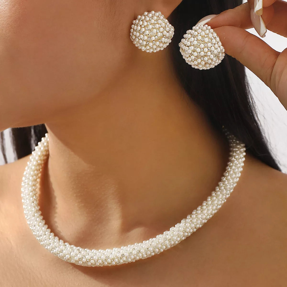 Woman wearing elegant pearl necklace and earring set jewelry